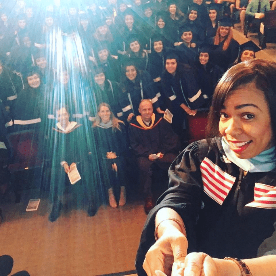 Photo shows Jennifer Reid Davis in front of the crowd of students, staff, and parents for Rauner College Prep's Graduation Commencement in 2016. Davis was serving as the principal of Rauner College Prep at the time.