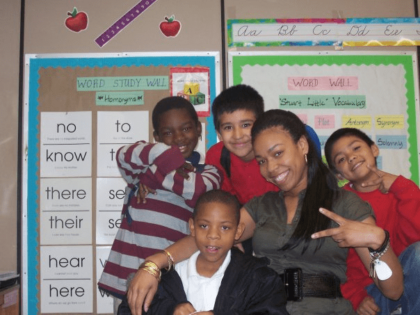 Photo shows Jennifer Reid Davis with her fourth grade students at the first school she taught at in Houston, TX