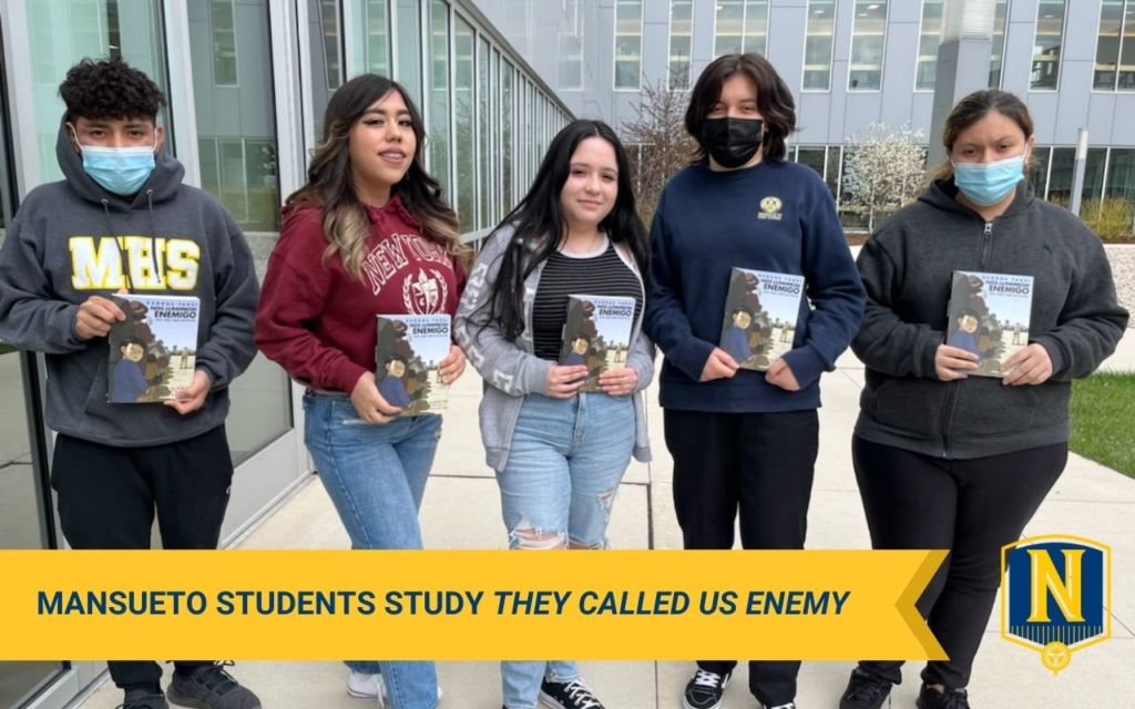 Photo shows Mansueto High School students posing with the graphic novel "They Called Us Enemy" or "Nos Llamaron Enemigo" by George Takei