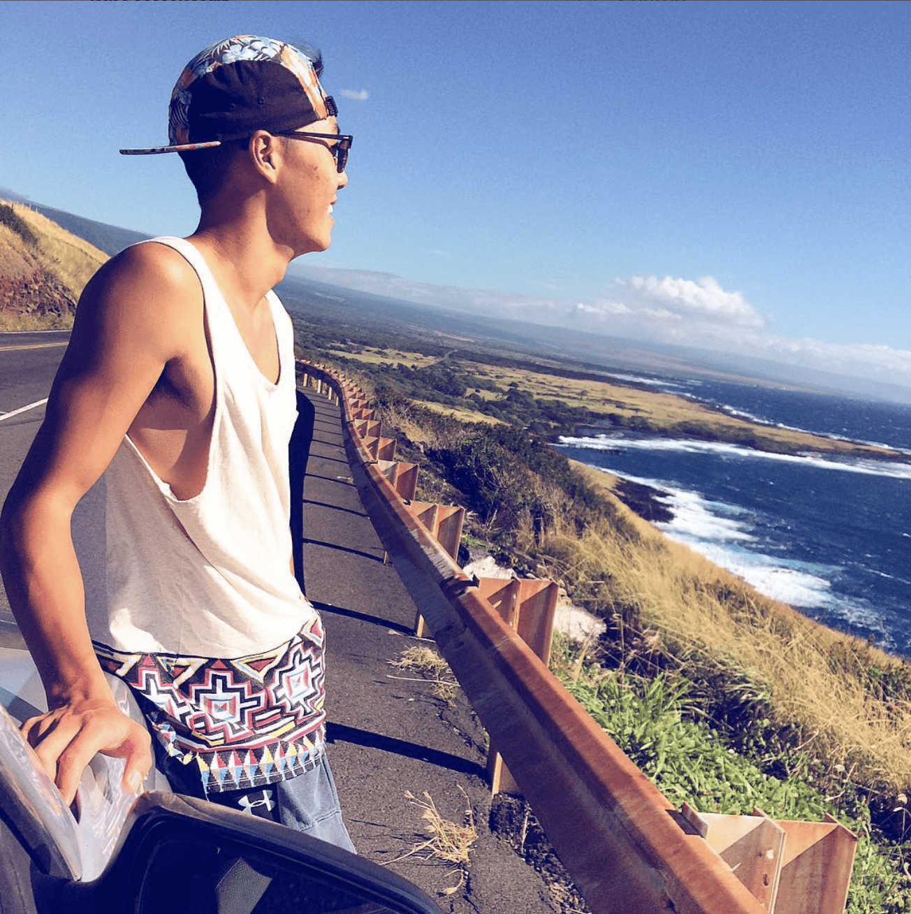 Photo shows JY Sun on the left in front of a beautiful view of the ocean in Ka'ū, a district in Hawai'i