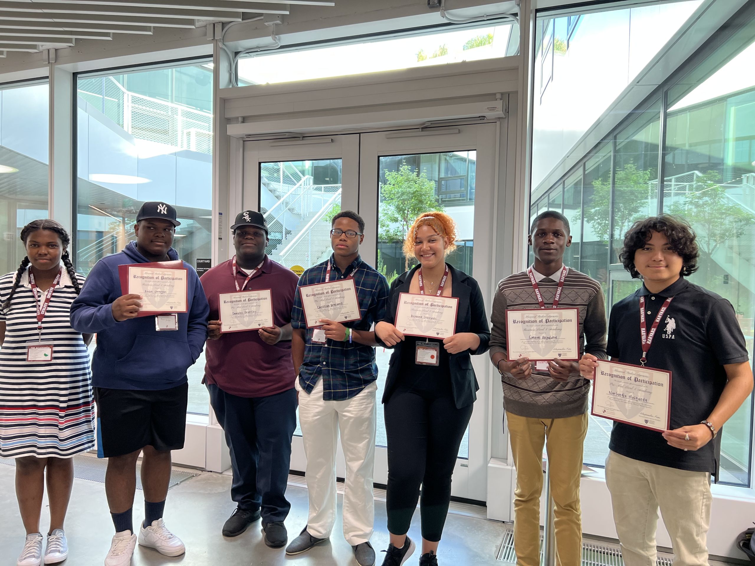 Photo shows 7 Baker College Prep students, posing with their certificates from Harvard University's Harvard Academies program for high school students