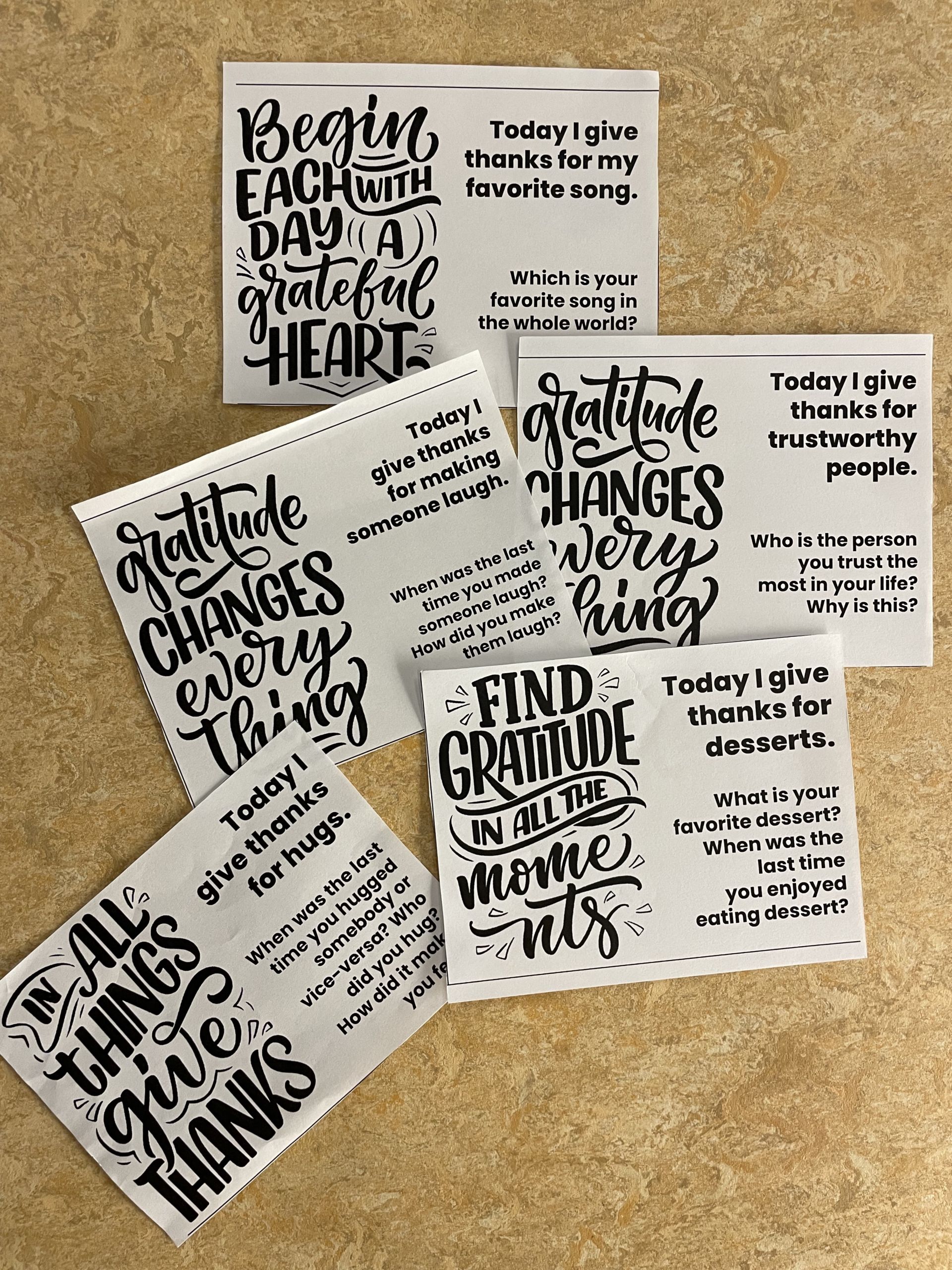 This image shows five gratitude cards at Muchin College Prep. The cards ask students to reflect on different things to be thankful for such as "Trustworthy people, desserts, hugs, making someone laugh, and favorite songs"