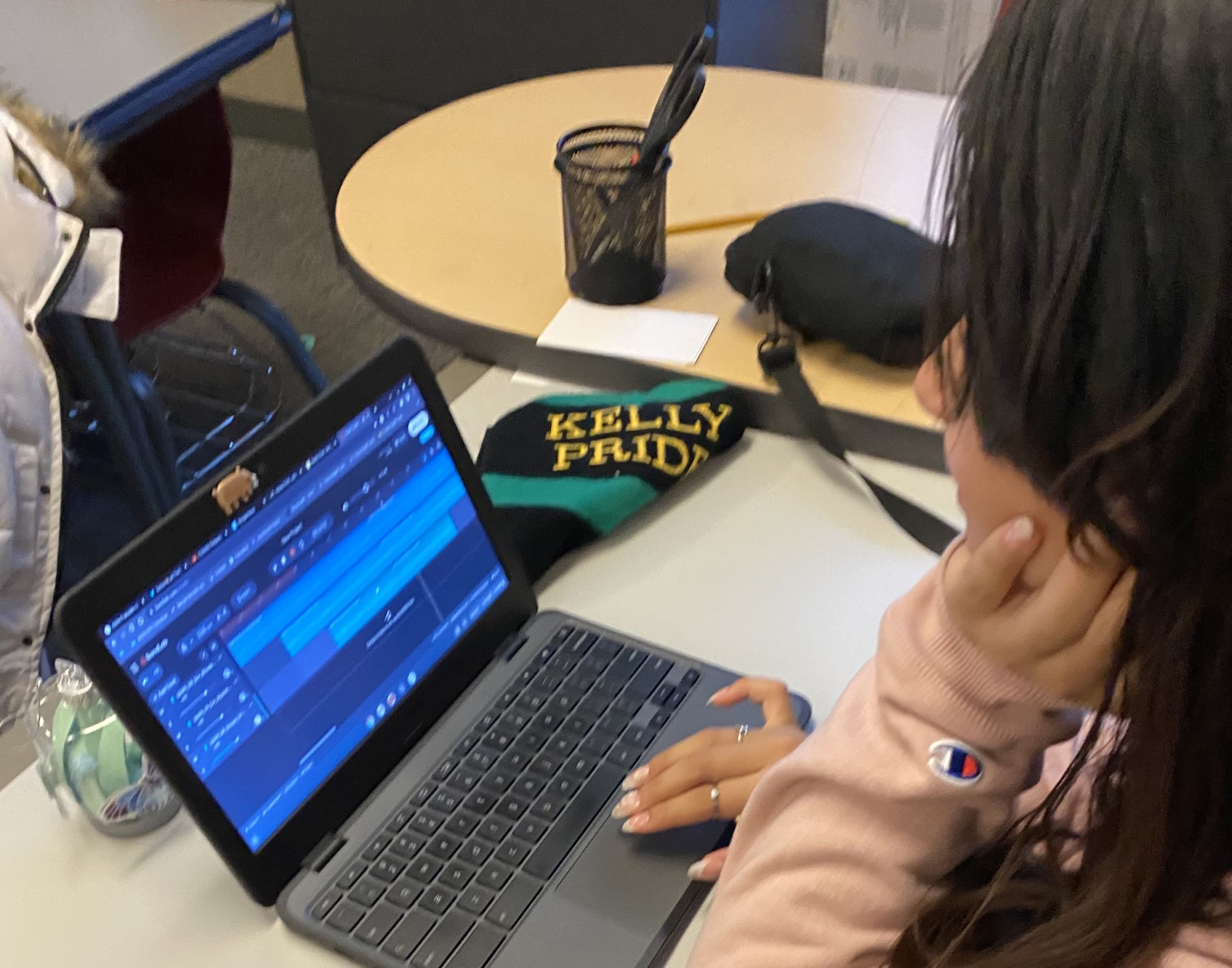 Photo shows Hansberry College Prep student Evely Hernandez creating music on her laptop on a classroom desk with a free software called Band Lab while at Beats Club. Evely is the leader of Beats Club.