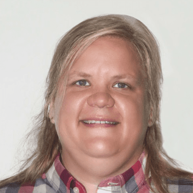 This photo shows a headshot of Ashley Norris Leverentz, the assistant principal at Gary Comer Middle School in Chicago, IL. Norris Leverentz is a white woman with medium length blonde hair and she is wearing a red, black, and white flannel.