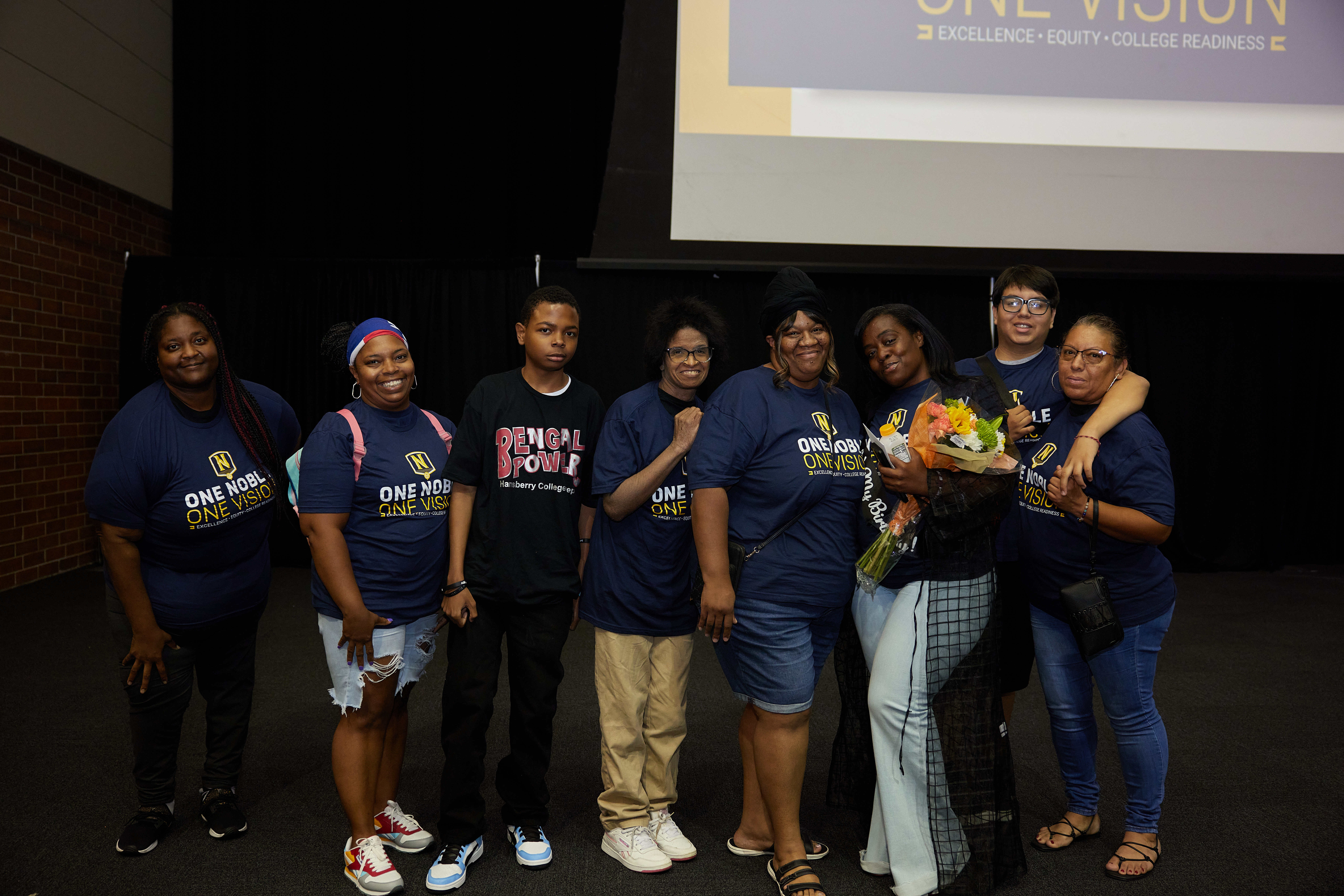 In this photo, many Noble Schools' parents are posing on the stage at the Noble Schools' Staff Kickoff for the 2023-2024 school year.
