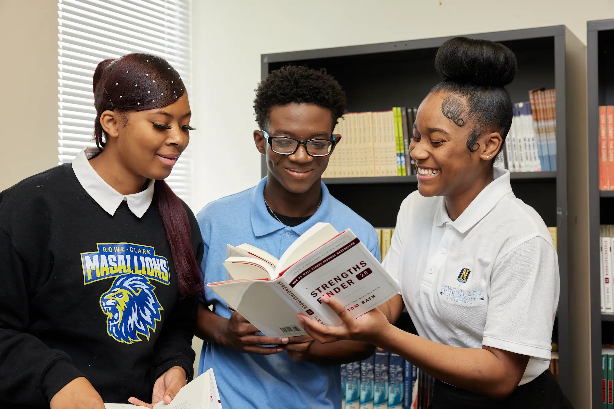Group Of Students holding a book and smiling