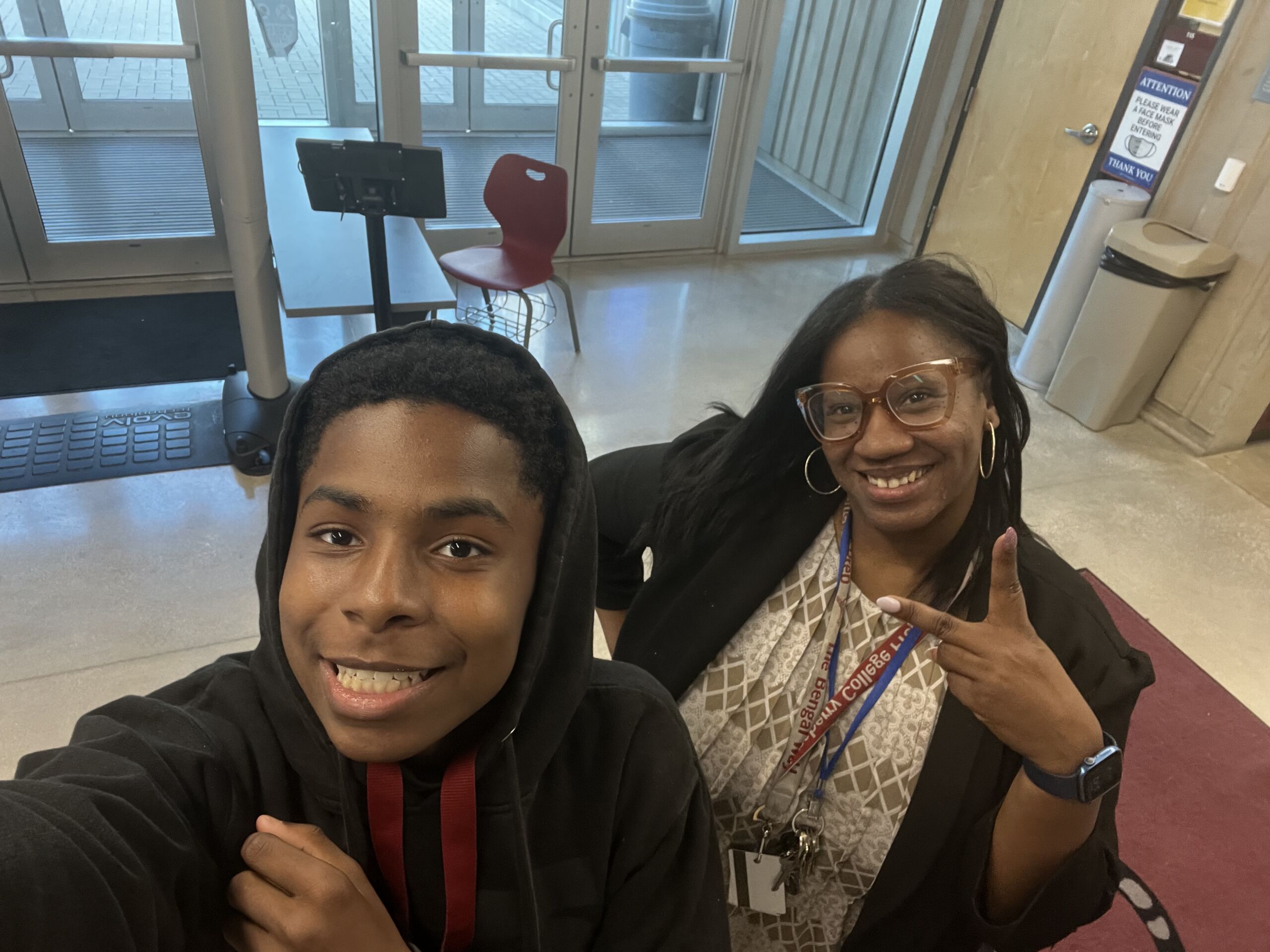 Photo shows Principal Kashawndra Wilson posing in a selfie with a Hansberry student by the school's front entrance.