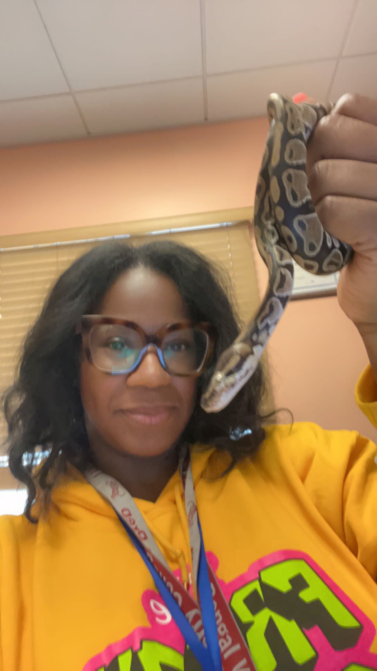Photo shows a selfie of Principal Kashawndra Wilson as she is holding her science classroom snake.