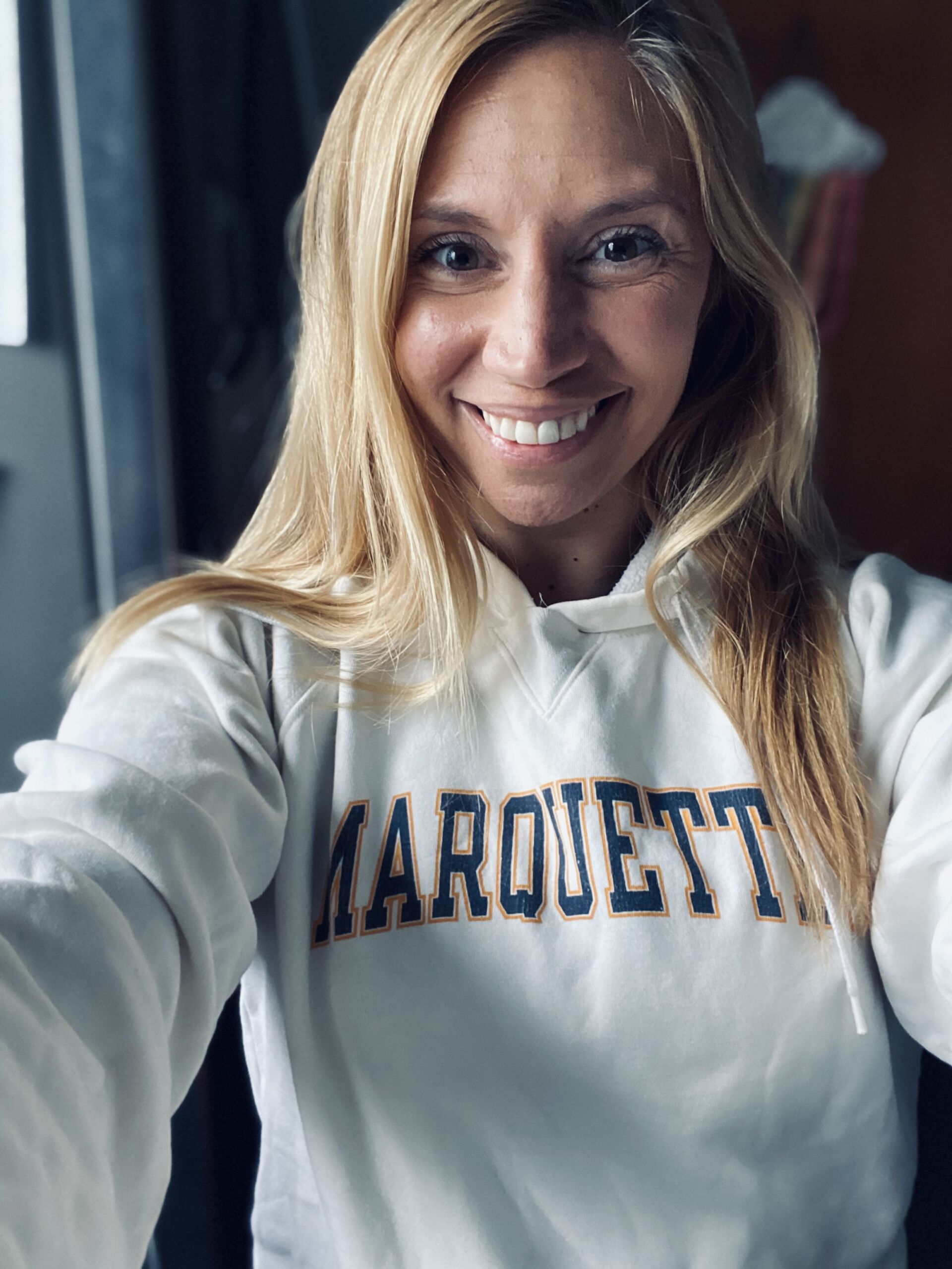 arrigo smiling wearing a white marquette hoodie