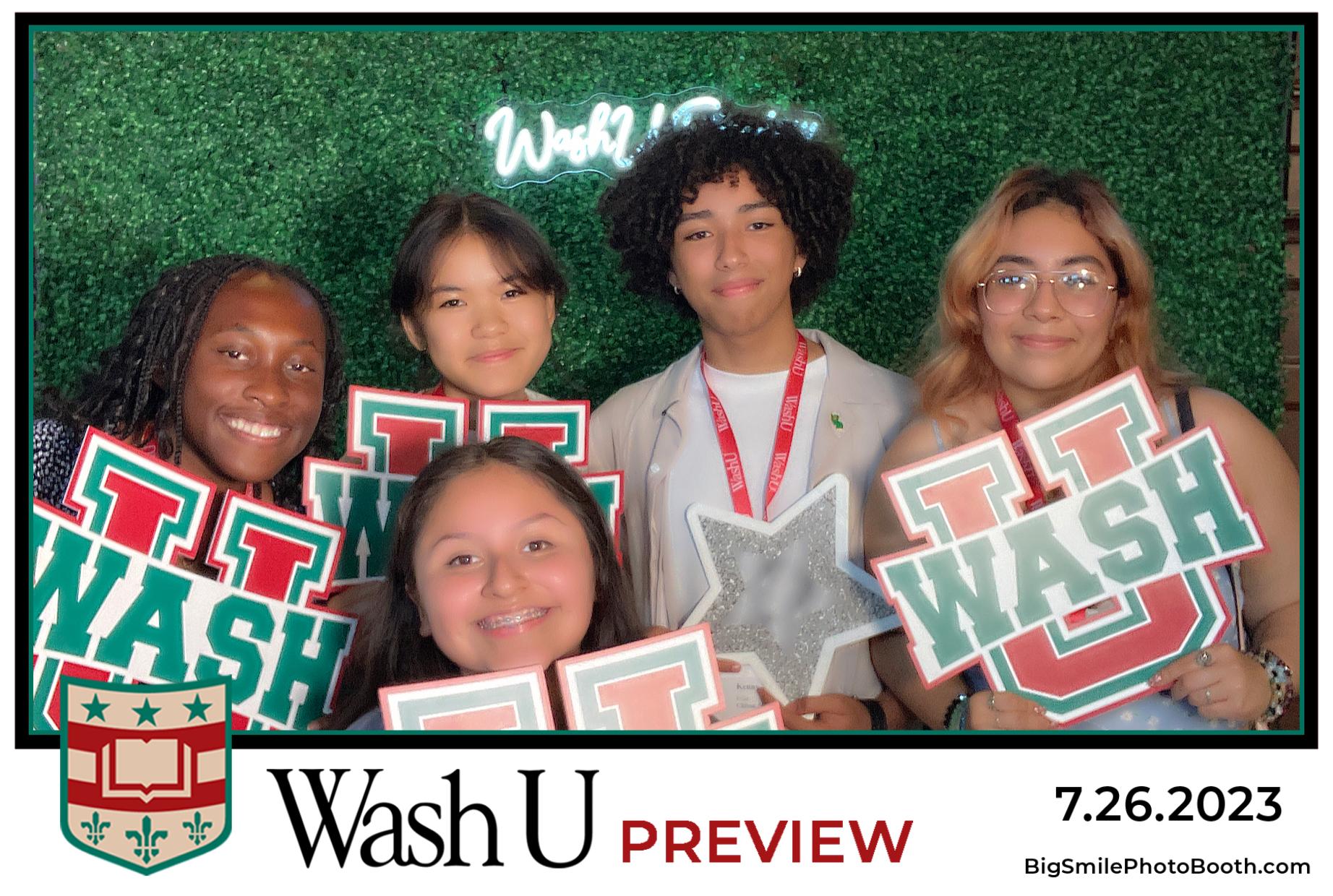 Harumi posed with classmates at a WashU event. They are all smiling and holding a sign that says "WashU".