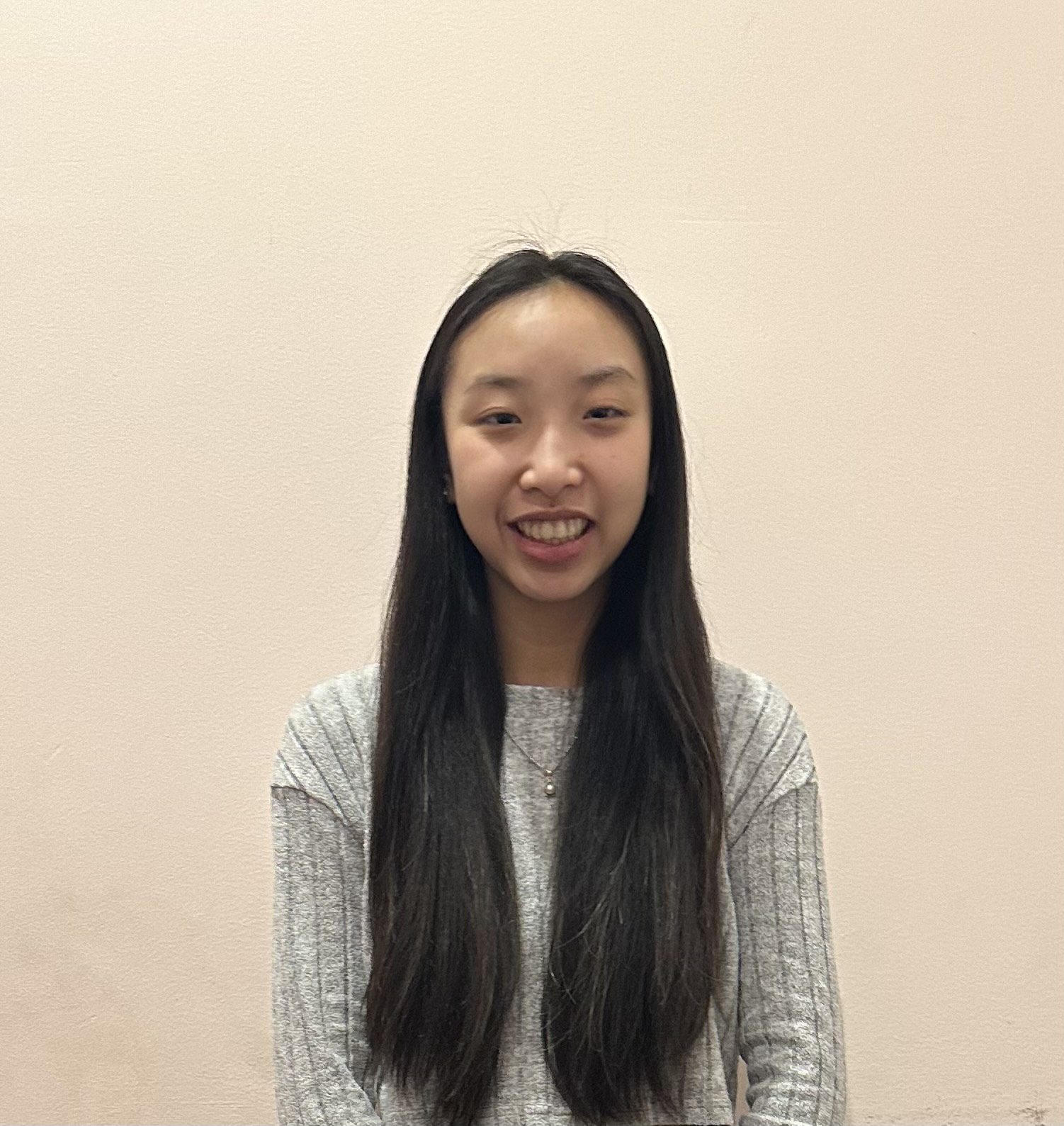 This photo shows a headshot of Chloe Cho, a student at UIC College Prep. She is a young Asian woman with long straight hair. In this photo, she is smiling and wearing a light gray sweater.