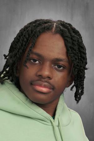 Photo shows a school headshot of Dorien Manning, a rising junior at Muchin College Prep. He is a young Black boy with medium-length twists. He is wearing a pastel green hoodie.