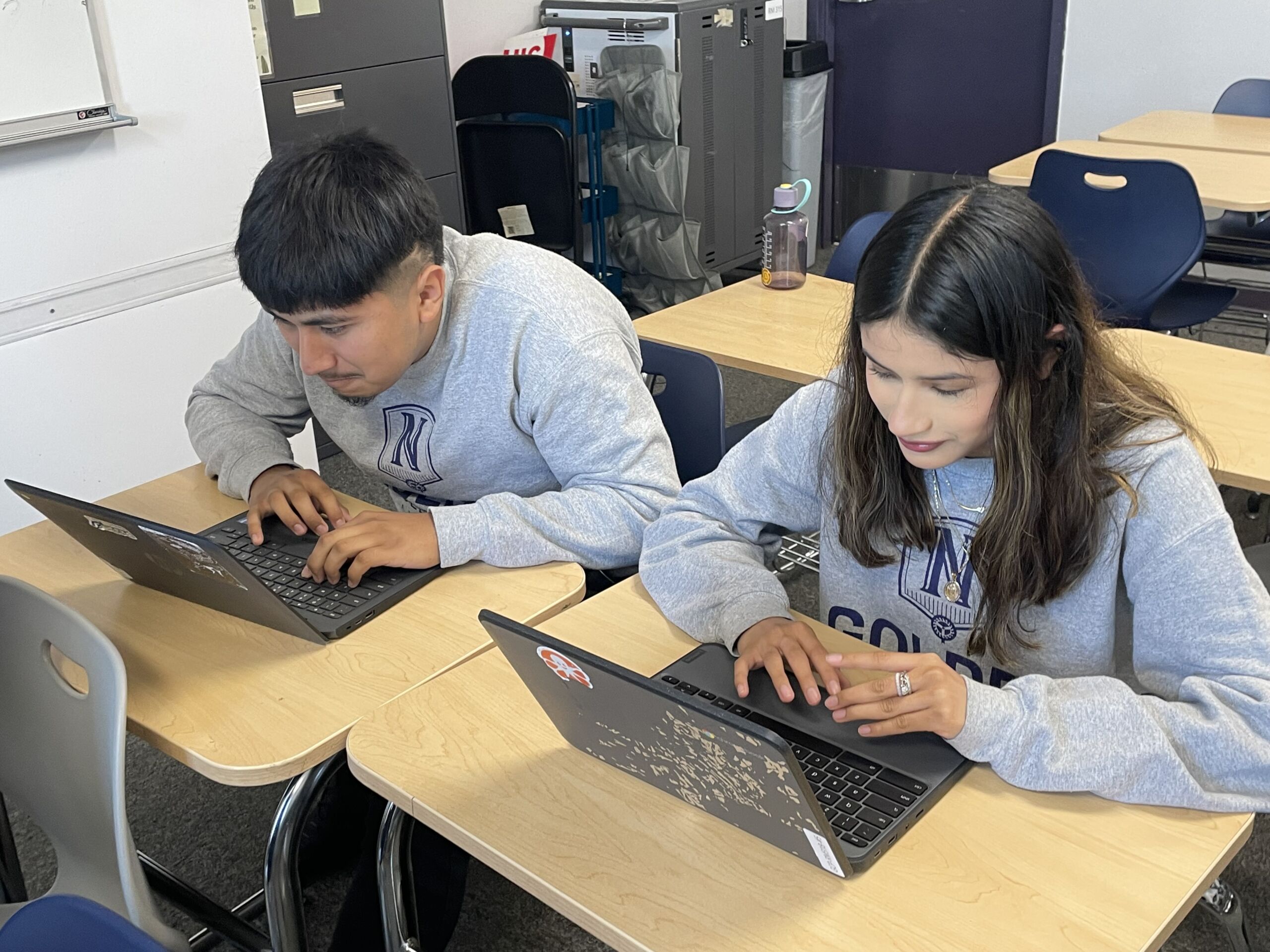 Photo shows two Golder College Prep students studying at desks in the classroom. Fabian Mendia, a member of the marching band and a rising senior, is on the left.