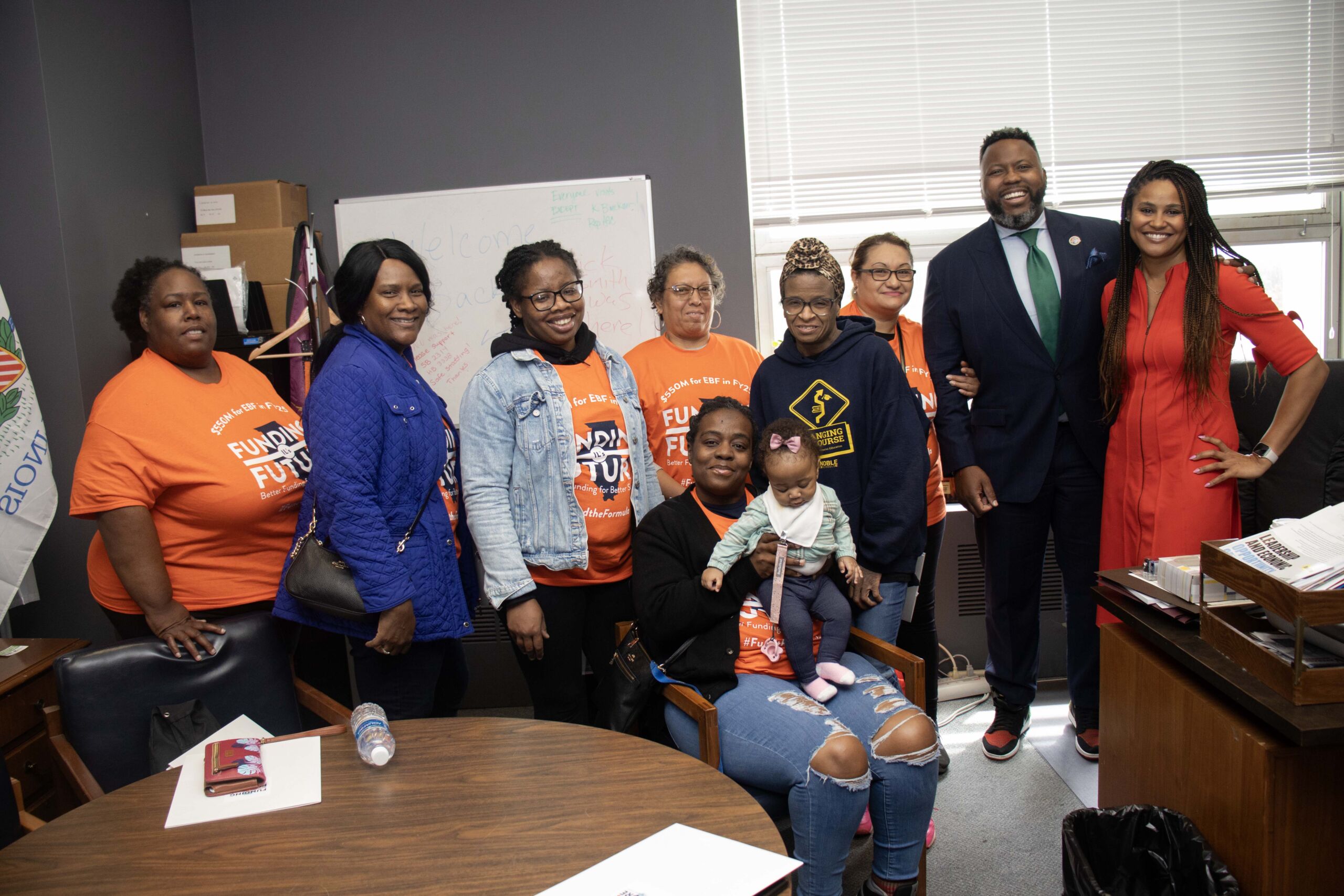 Constance Jones, CEO of Noble Schools, stands next to Representative Kam Buckner alongside Noble parents after they talked with him in his office in Springfield.