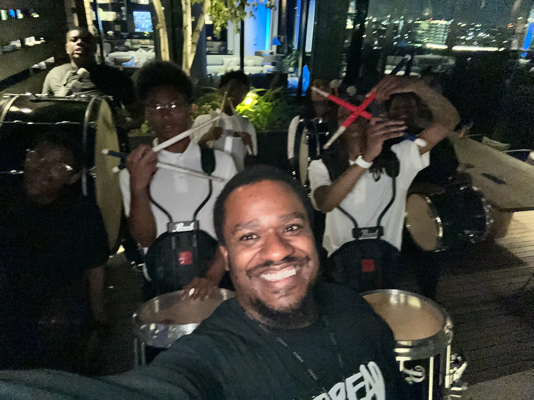 Tapley takes a selfie with some of his band students. They are holding drums and posing.