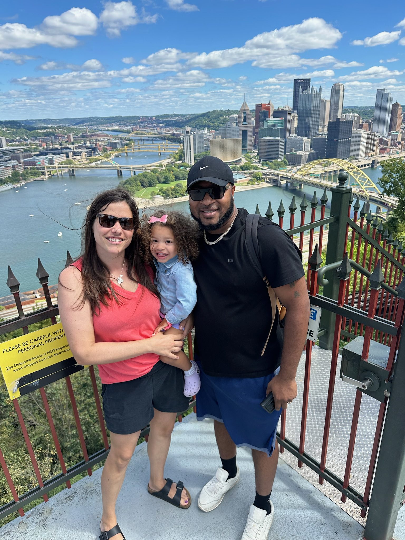 Lockhart with her husband and daugher outside. The city skyline of Pittsburg, Pennsylvania is behind them.