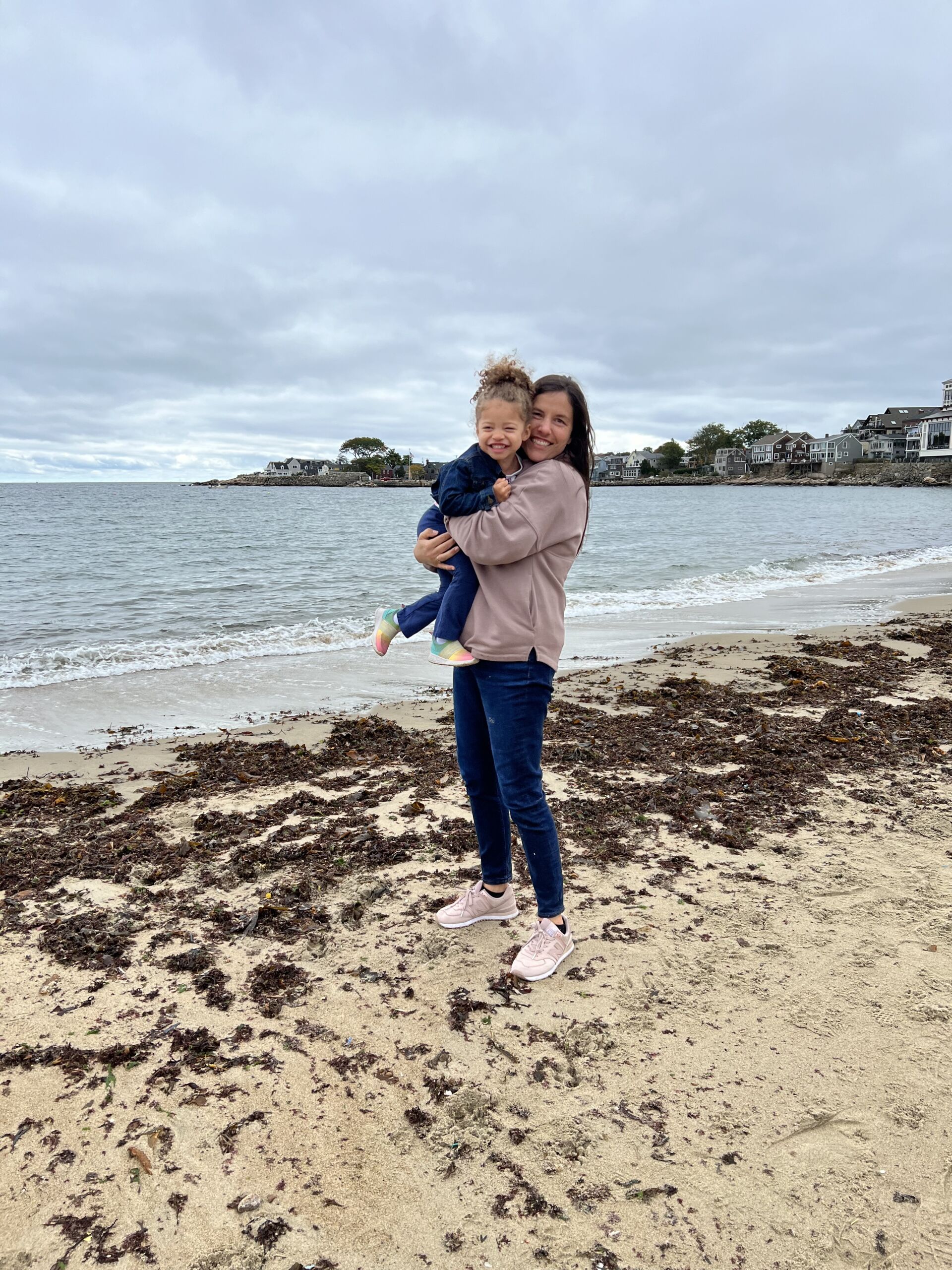 Lockhart holding her daughter on the shore of a beach.