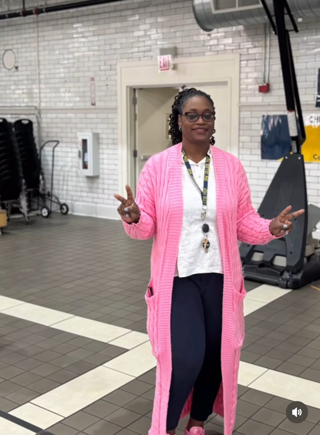 Principal Tina Ellis at DRW College Prep is posing in the main hall with peace signs.