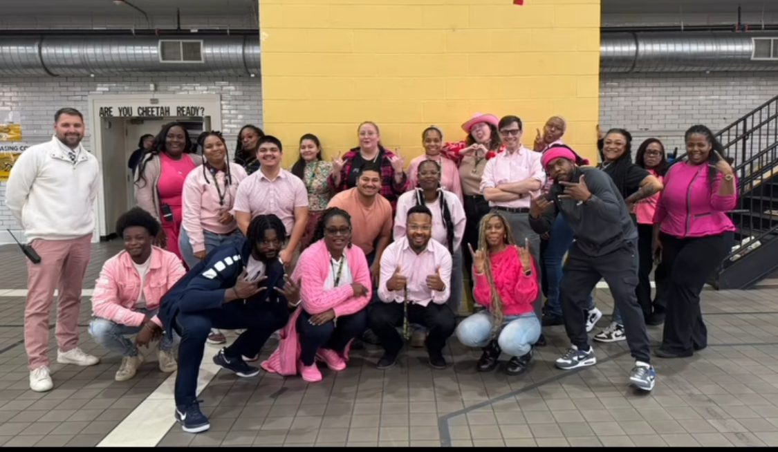 Principal Ellis with many staff members at DRW College Prep, all dressed up in pink.