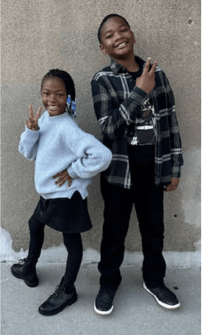 Burns' two kids smiling and posing with peace signs.