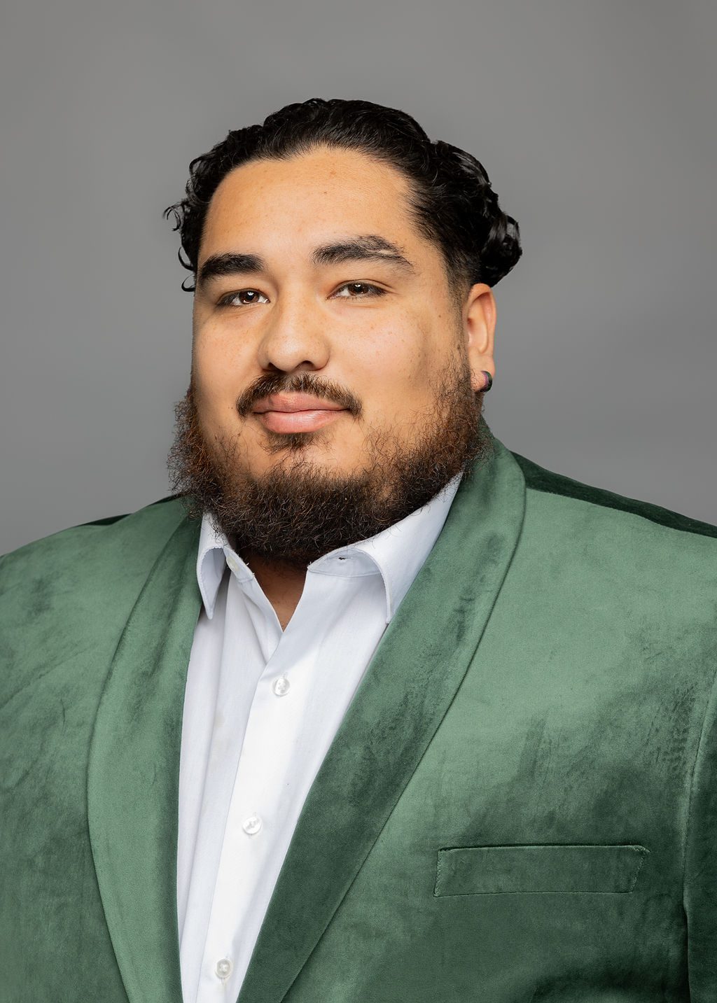 Headshot of Juan Pablo "JP" Esquivel. He is a man with light brown skin, short wavy black hair with the sides shaved, and a medium-length beard. He is smiling slightly and wearing a light green blazer over a white button-up.