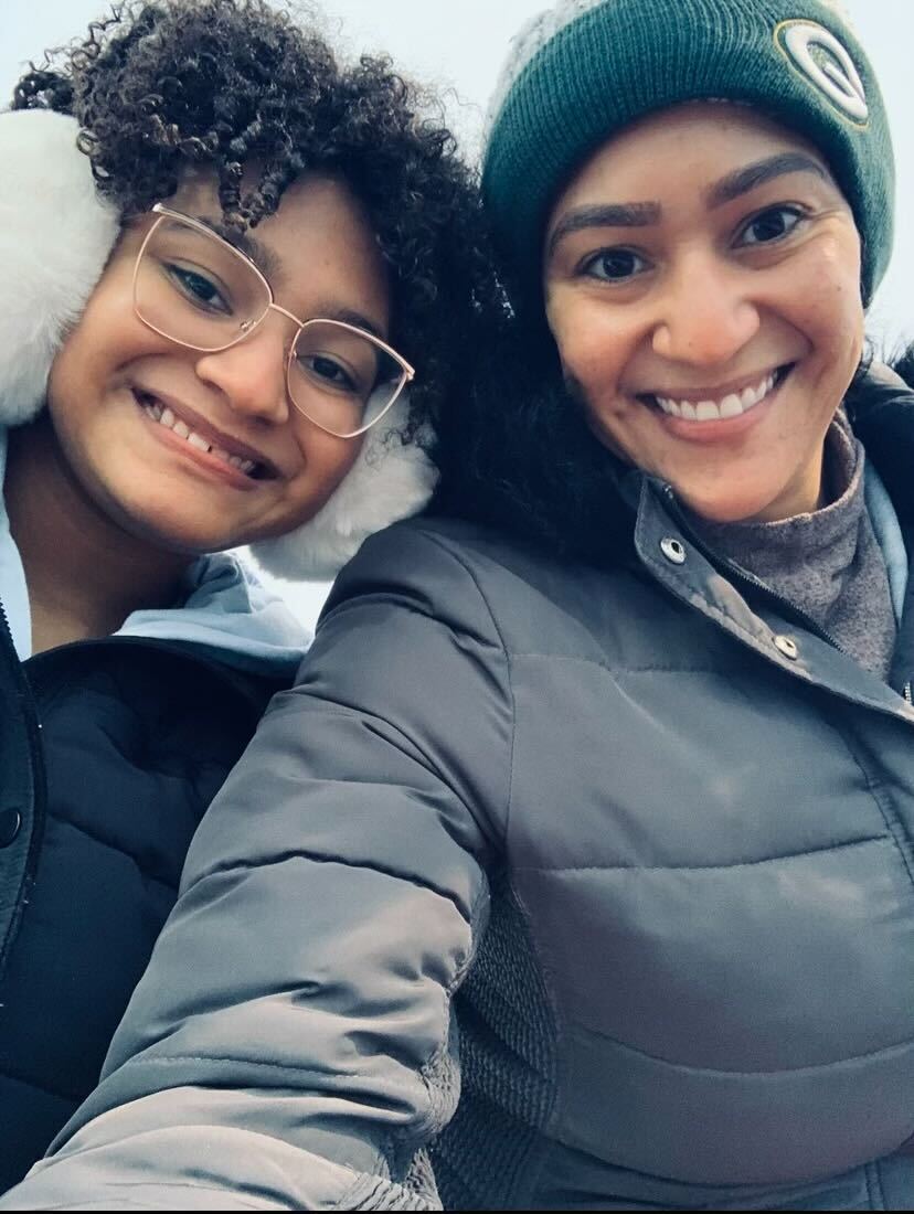 Cora and her daughter Janeece take a selfie outside. They are wearing cold weather clothes and smiling.