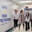 Four students and staff members walk down a hallway at Noble Street College Prep, smiling and talking. On the wall, there is a decal that says "Love and High Expectations since 1999"