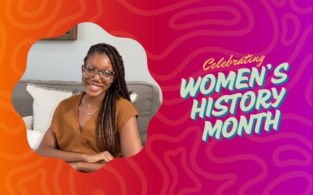 A photo of Sydney Clayborn, a woman with light brown skin and dark brown braids with light highlights, sits on top of an orange and pink ombre background with a squiggle pattern. To the right of the photo is white, orange, and blue text that reads "Celebrating Women's History Month"