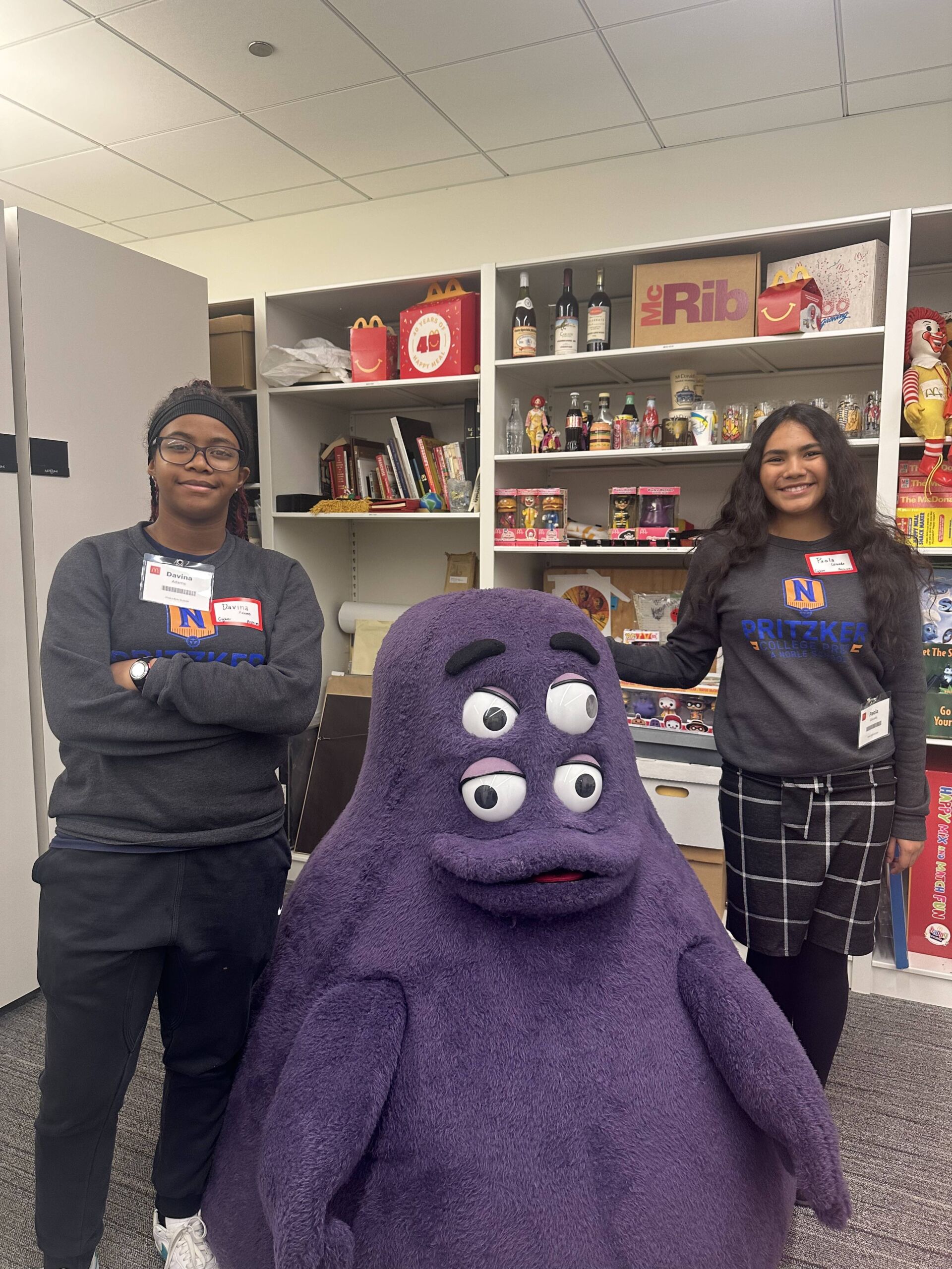 Paola C Grab A Byte Two Pritzker College Prep students pose for a photo with Grimace, the McDonald's mascot. Paola is on the right.