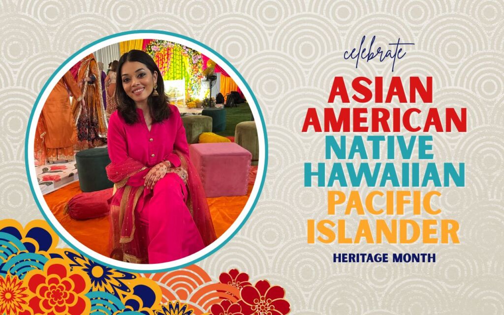 A full-body image of Afsha Wasi, a teacher at Noble Street College Prep, in bright pink traditional South Asian clothing is on top of a beige background with a rippling circle pattern. Below the image to the left is a group of colorful illustrated flowers. To the right of the image are the words "Celebrate Asian American, Native Hawaiian, and Pacific Islander Heritage Month".