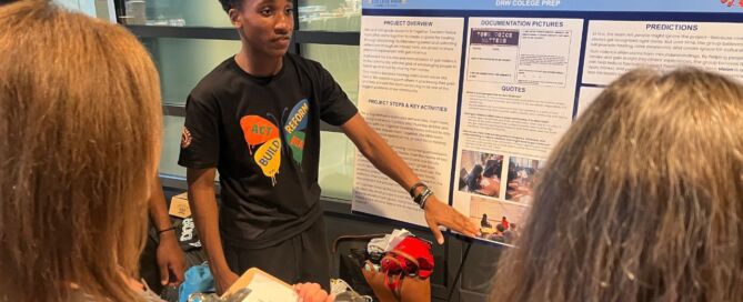 Jamill Willis, a student at DRW College Prep, points to a posterboard with his group's Together Towards Peace project, which addresses gun violence in our communities.