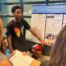 Jamill Willis, a student at DRW College Prep, points to a posterboard with his group's Together Towards Peace project, which addresses gun violence in our communities.