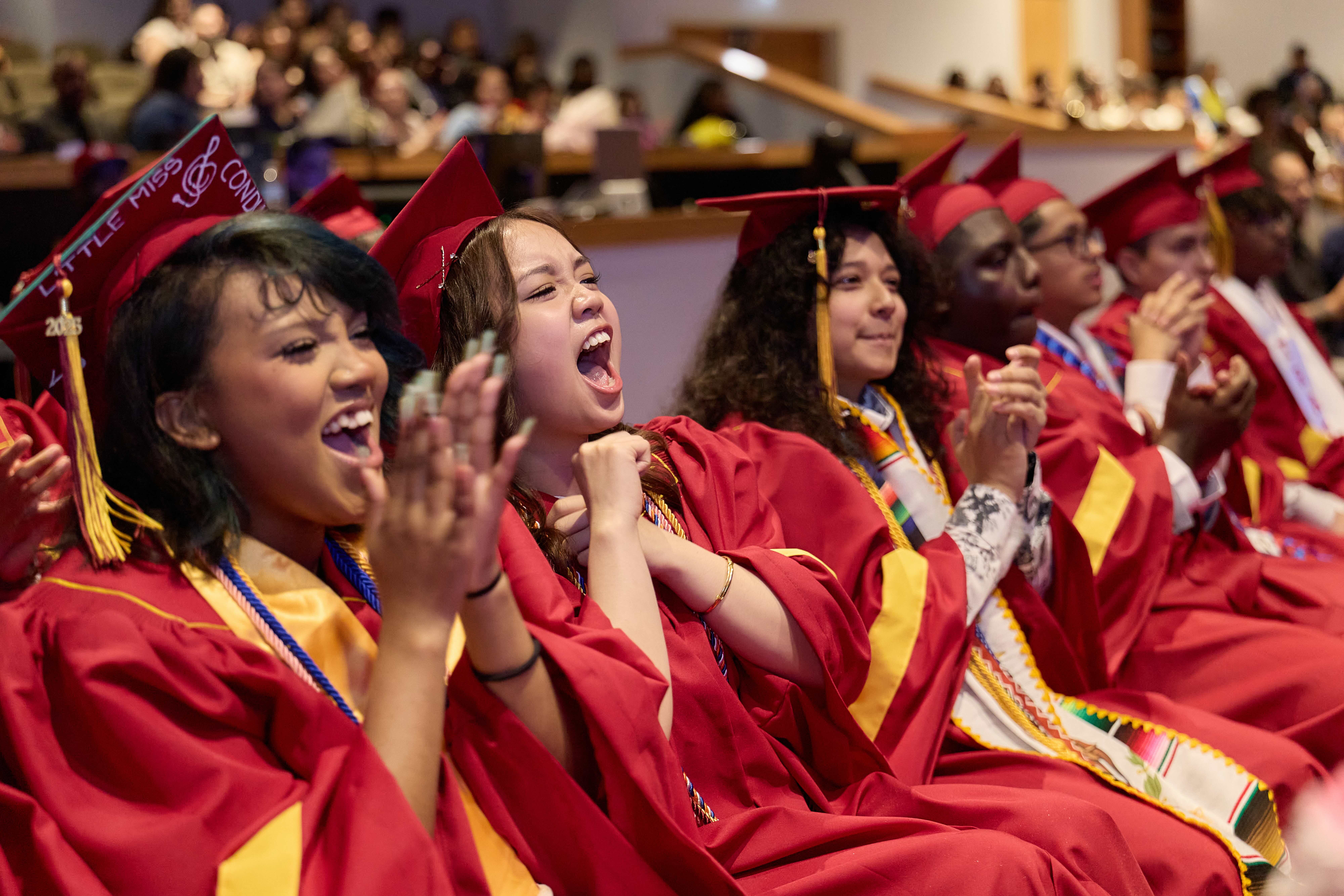 Several students cheer at TNA's graduation. In the center, one is shouting excitedly.