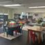 Johnson College Prep's in-house library is full of tables, plush chairs, bean bags, and bookcases. It is well lit and looks cozy with rugs spread out all across the room. A large mirror is on the wall, reflecting most of the spacious library.