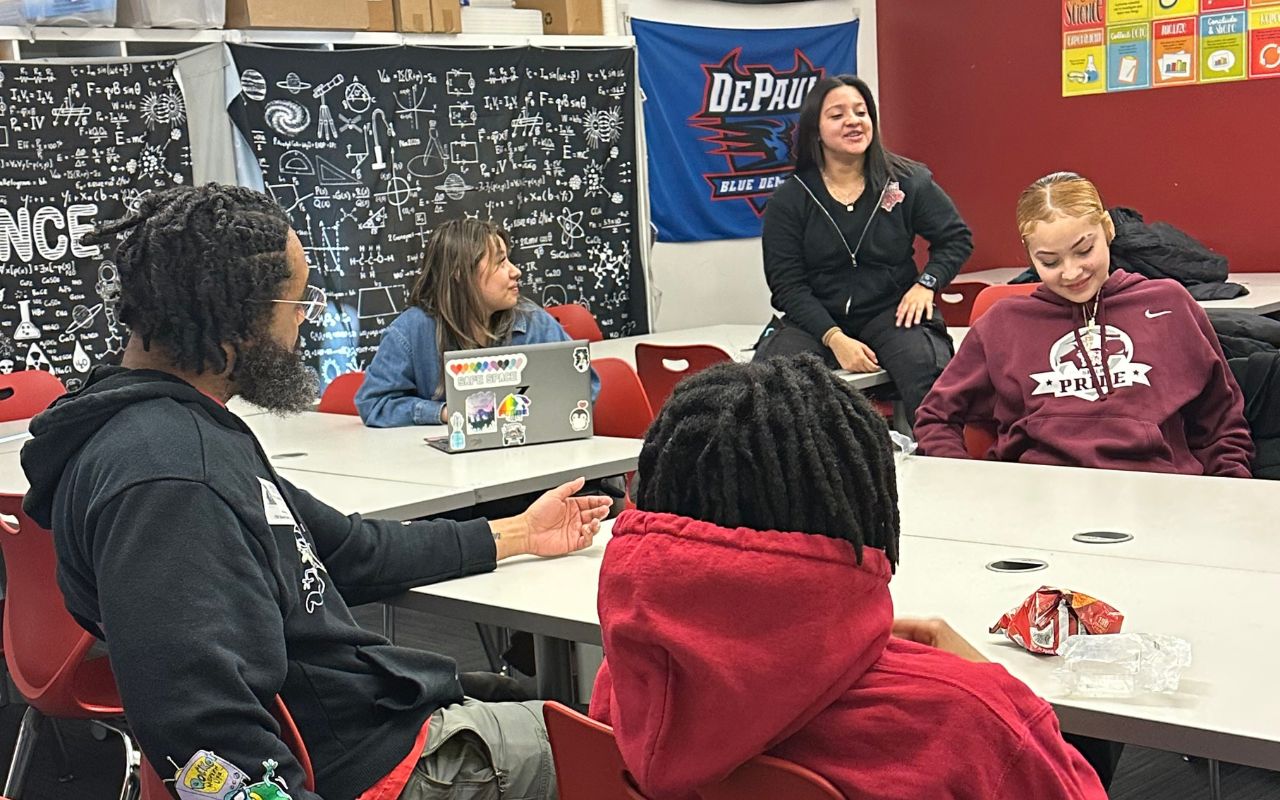 A group of ITW David Speer Academy students sit in a circle at classroom desks with a NAMI staff member. They are actively discussing something and look very comfortable and safe with the group.
