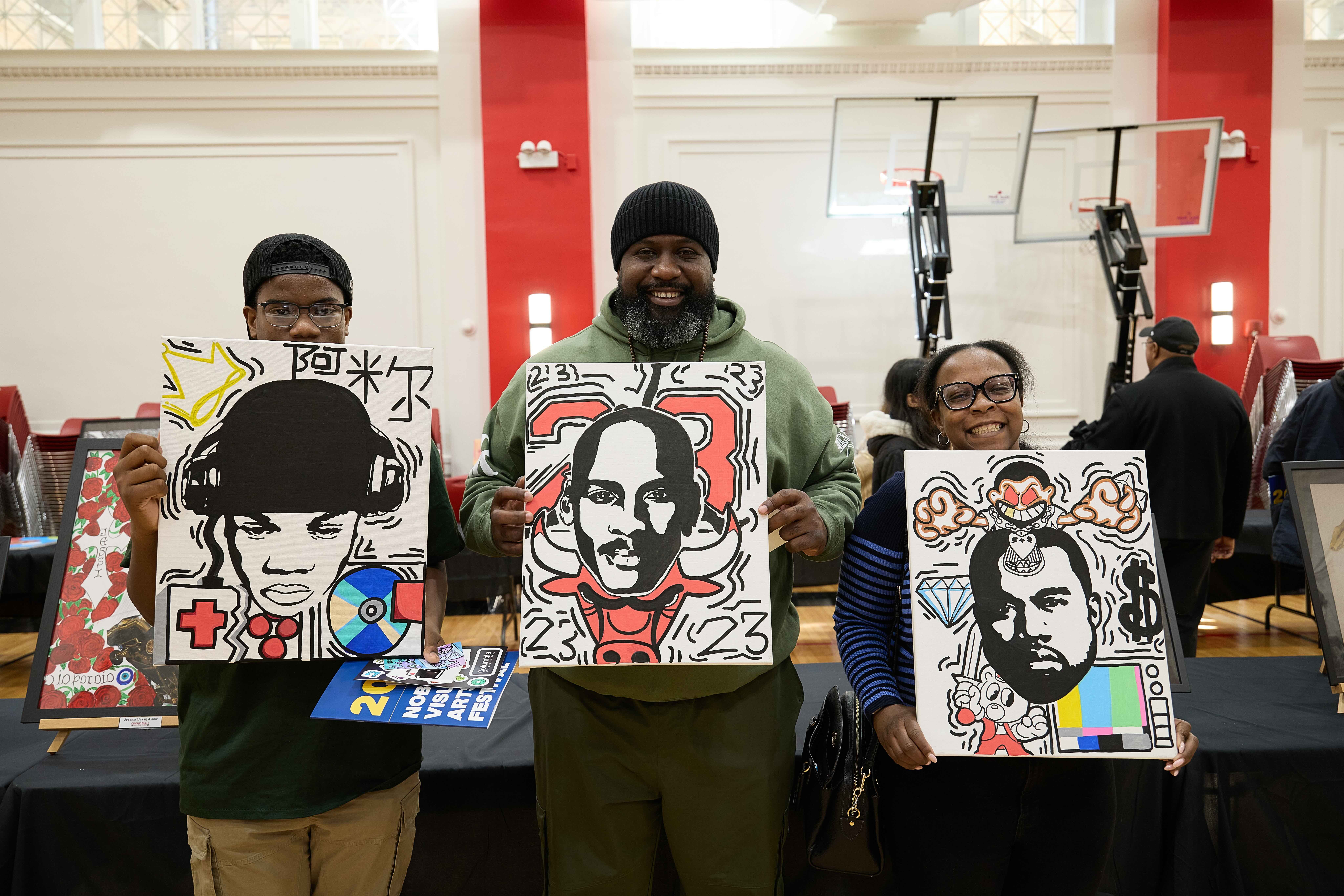 Student artist Amir Lewis stands with two of his family members as they all hold up his three matching art pieces. They are all clean black and white portraits with pops of solid color. They each depict a different person surrounded by objects like a gamepad, an old TV, the Chicago Bulls mascot, a diamond, a CD, and more. Amir is a Hansberry College Prep student with short black hair underneath a backwards black baseball cap and brown skin. He wears glasses and hides his smile behind the canvas he's holding.