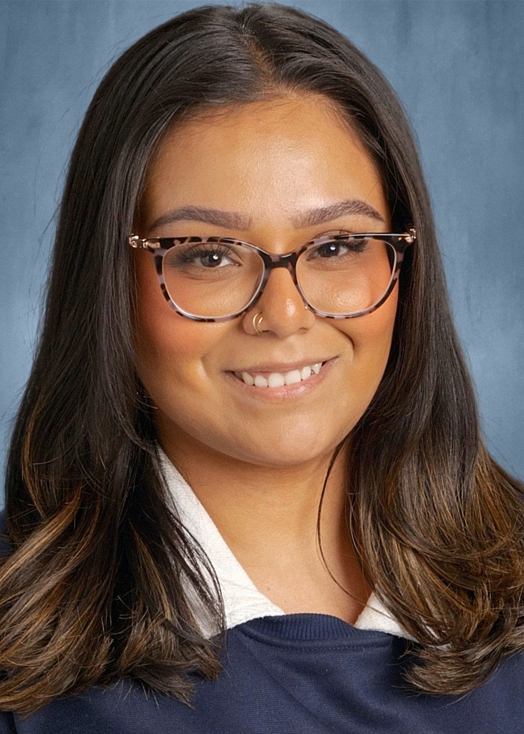 Carla Oshima DLF Cohort 2025 Headshot of Carla Oshima. She is a an Asian woman long brown shoulder length hair. She is smiling and wearing glasses and a white shirt and navy blue sweater.