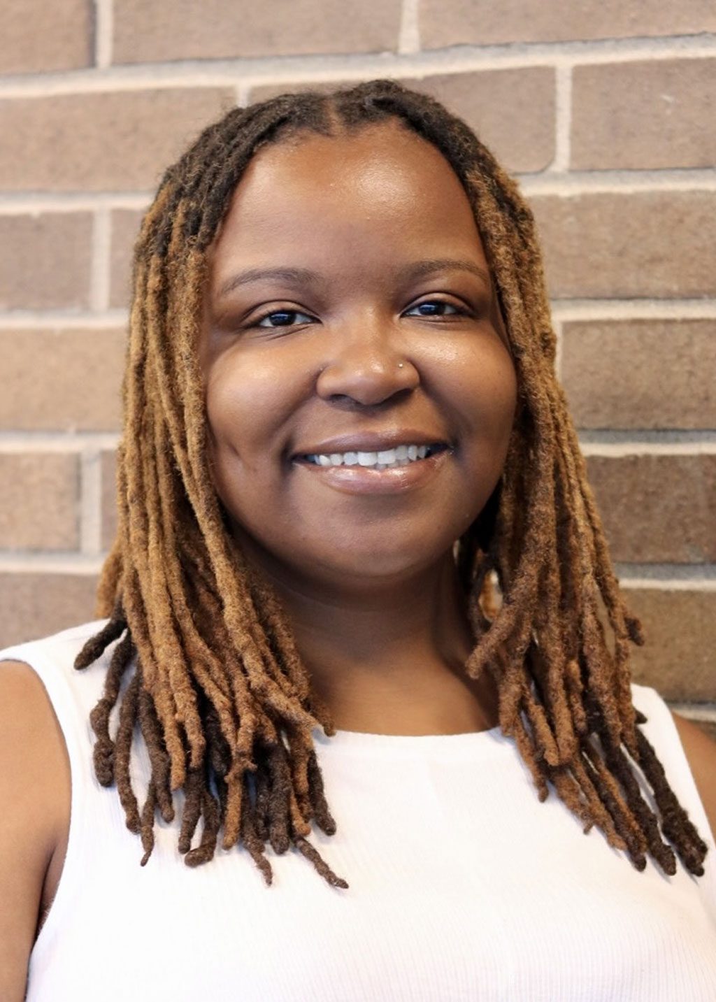 Keena Preston DLF Cohort 2025 Headshot of Keena Preston. She is a Black woman and short brown locs that go down to her shoulders. She is smiling and wearing a white top.