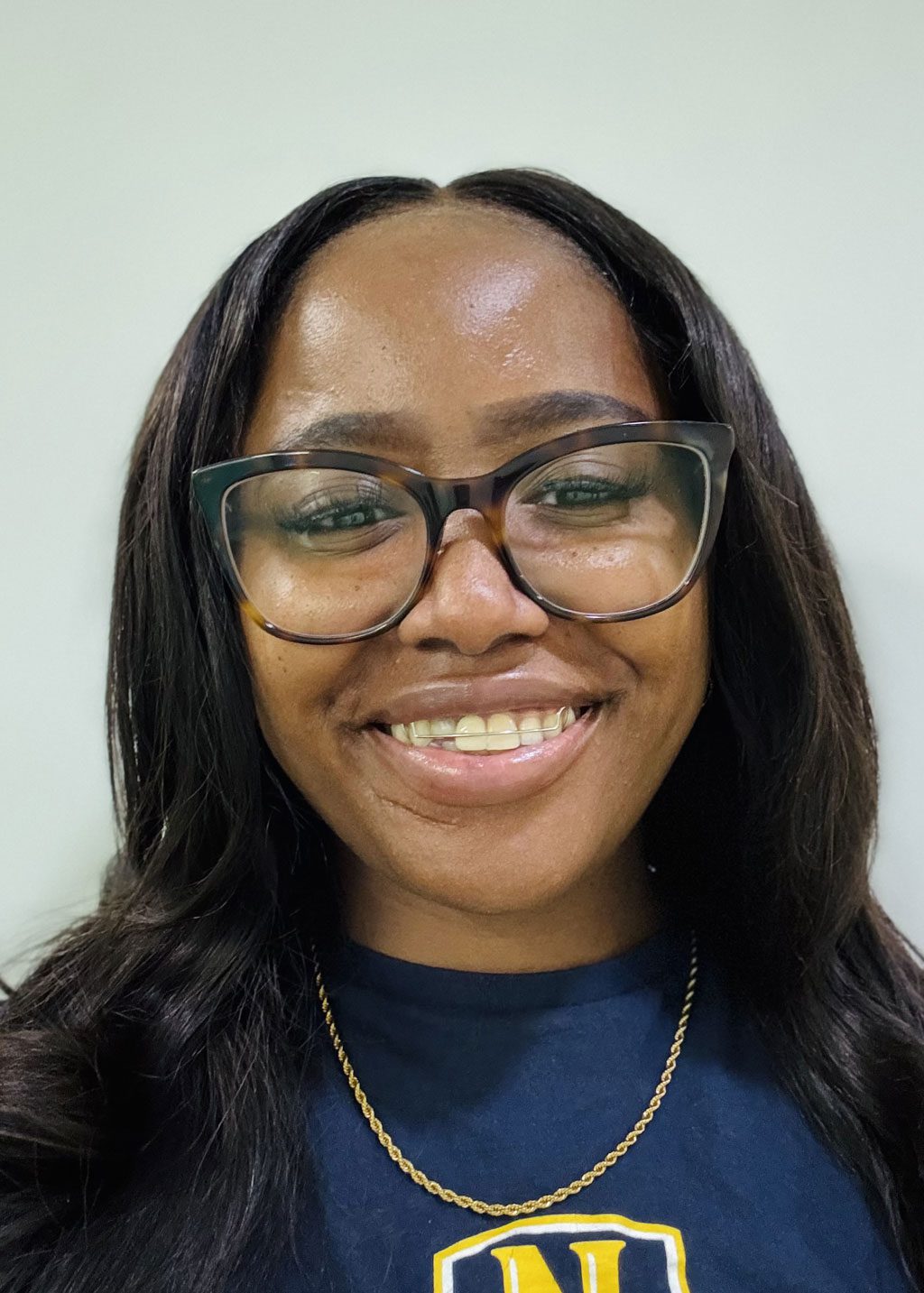 Raeven Funnye DLF Cohort 2025 Headshot Raeven Funnye. She is a Black woman and long black hair that goes down below her shoulders. She is smiling and wearing glasses and wearing a Noble Schools navy blue t-shirt.