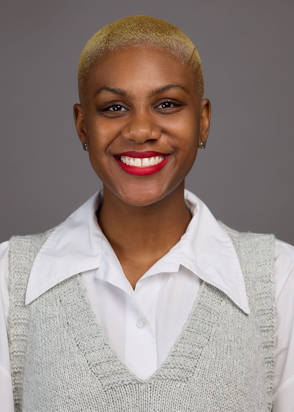 Tatyana Hyde DLF Cohort 2025 Headshot Tatyana Hyde. She is a Black woman and short black blonde hair. She is smiling and wearing a light gray vest over a white business shirt.