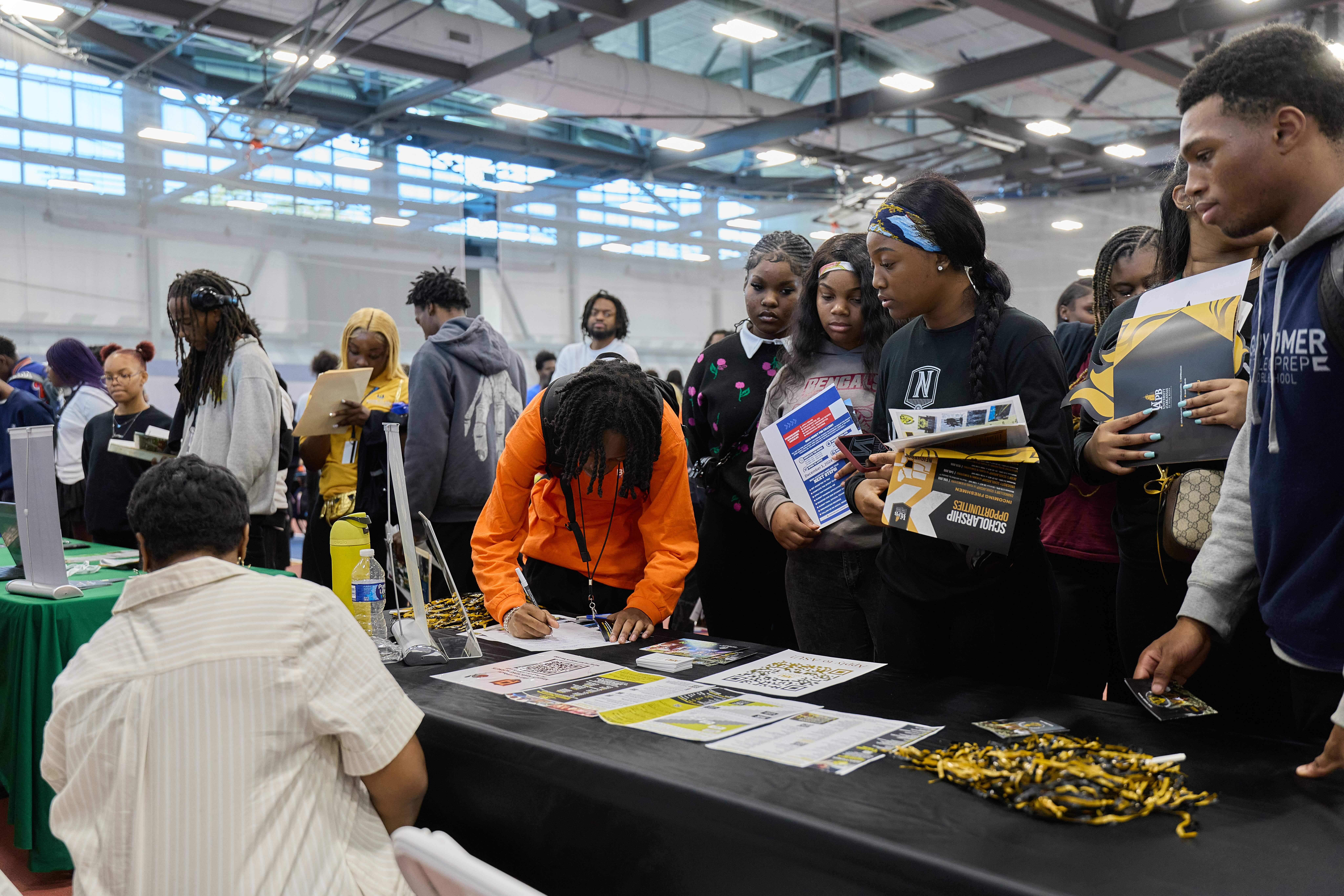 Group of Noble School students talking to a college representative booth at the HBCU College Fair