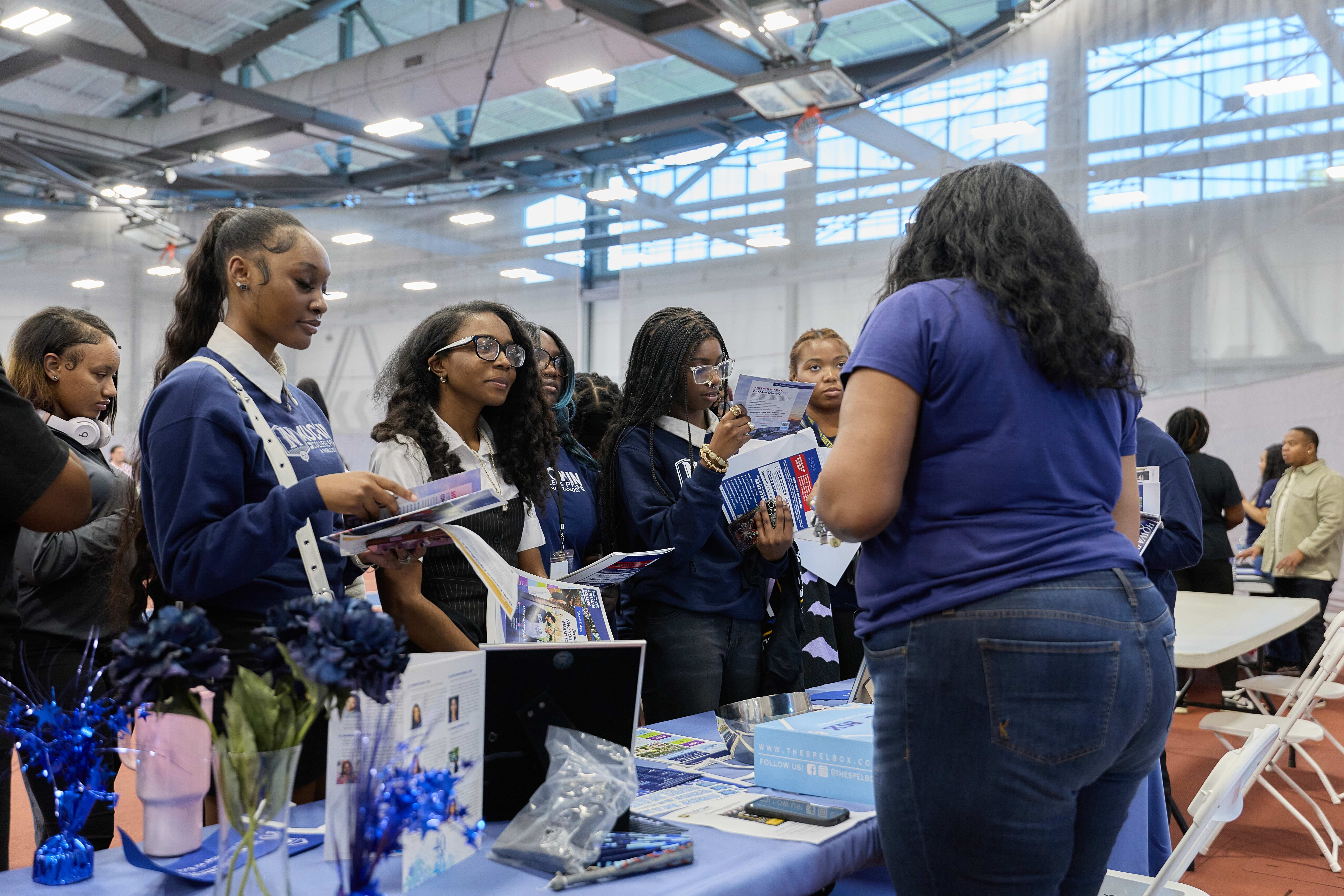 A group of Muchin College Prep students talking with a HBCU representative at the HBCU college fair.