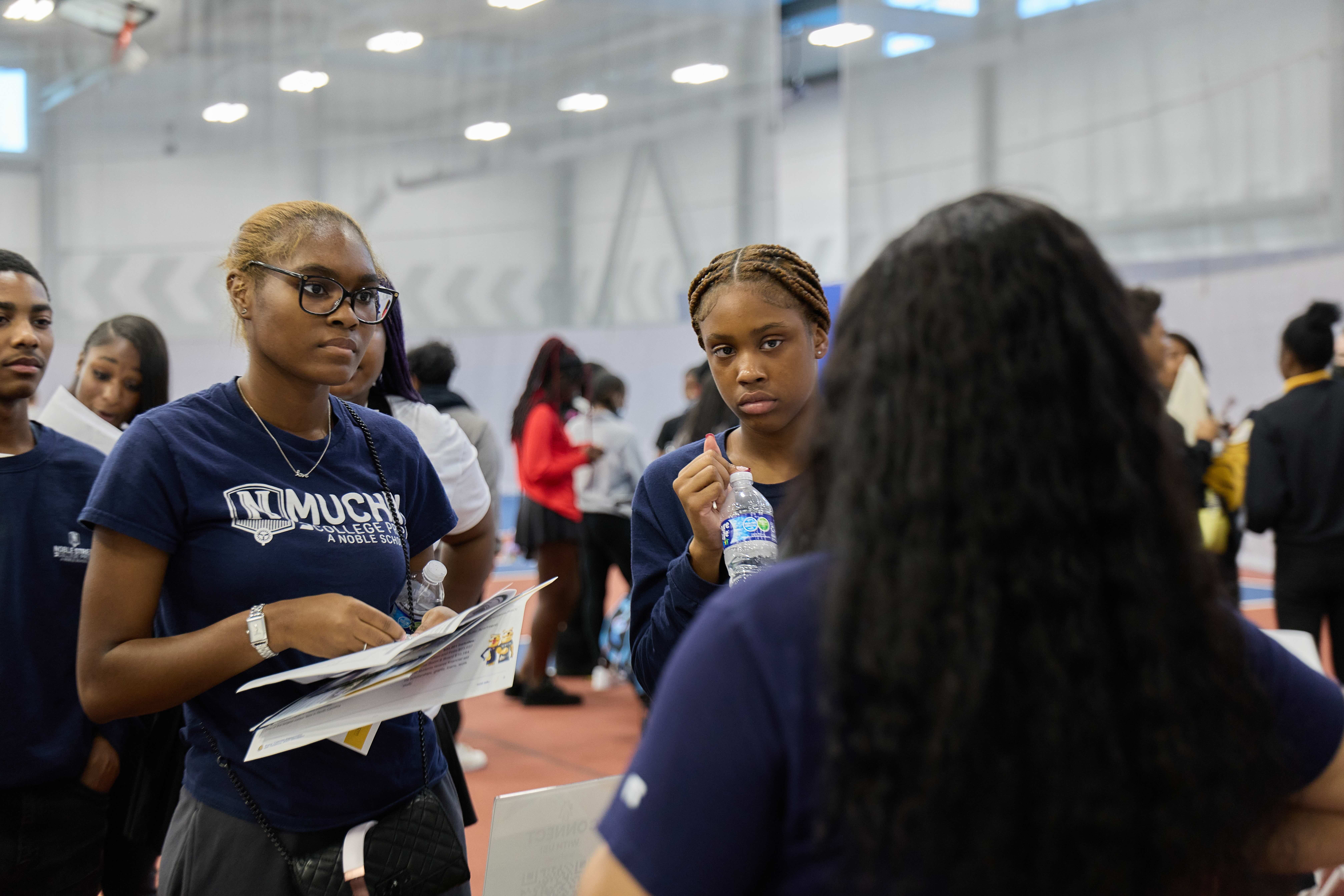 Two Muchin College Prep students talking with a HBCU representative at the HBCU College fair.