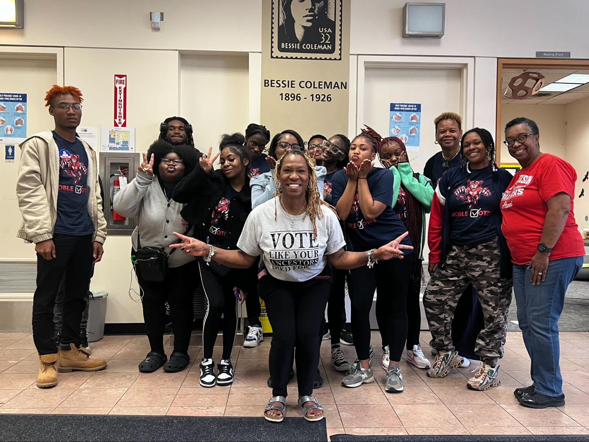 Wright and Powell-Kelley pose for a photo with students in the Coleman branch building.