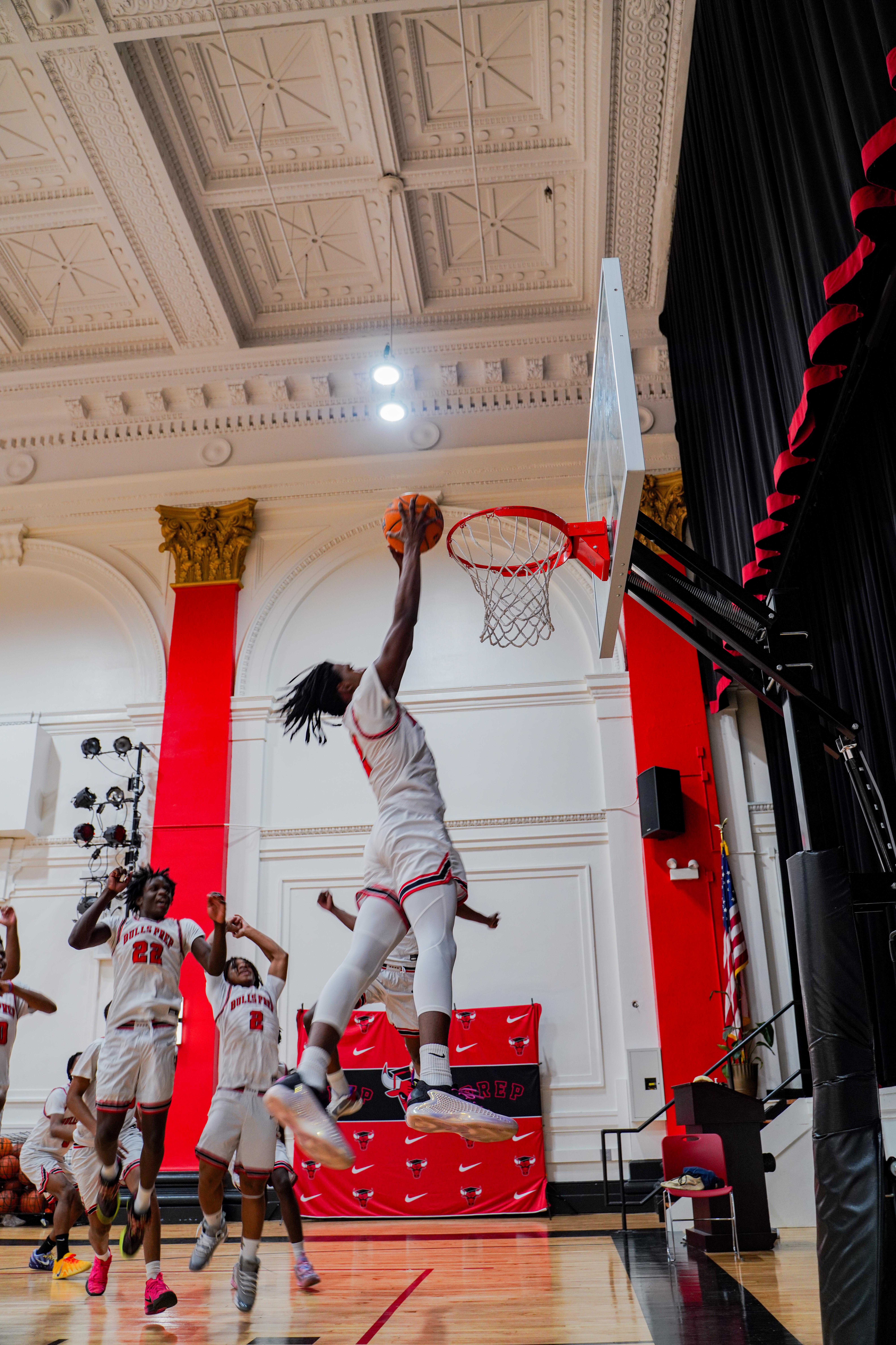 Mehki jumps up high to dunk the ball. It is almost but not quite touching the rim.