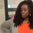 Ta-Tanisha Hall, an African American Literature teacher at ITW David Speer Academy in Chicago, IL, stands at the door to her classroom. She is smiling confidently and standing next to the plaque on the side of her door that says "Tanisha Hall, Distinguished Teacher, 2022-2023"