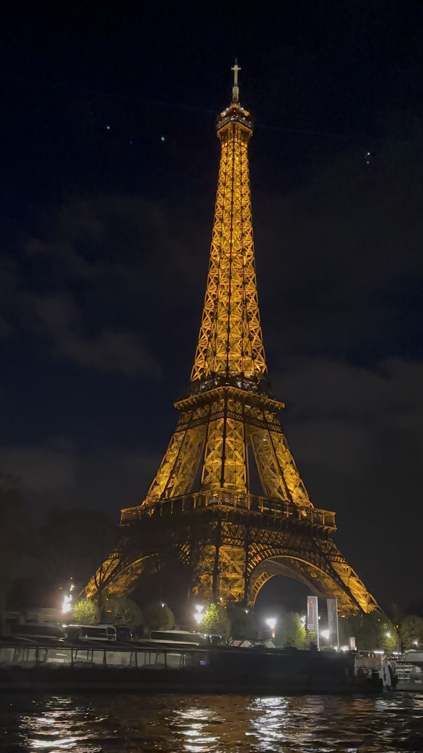 untitled (2) The Eiffel Tower towers above the river, lit up in the night sky.
