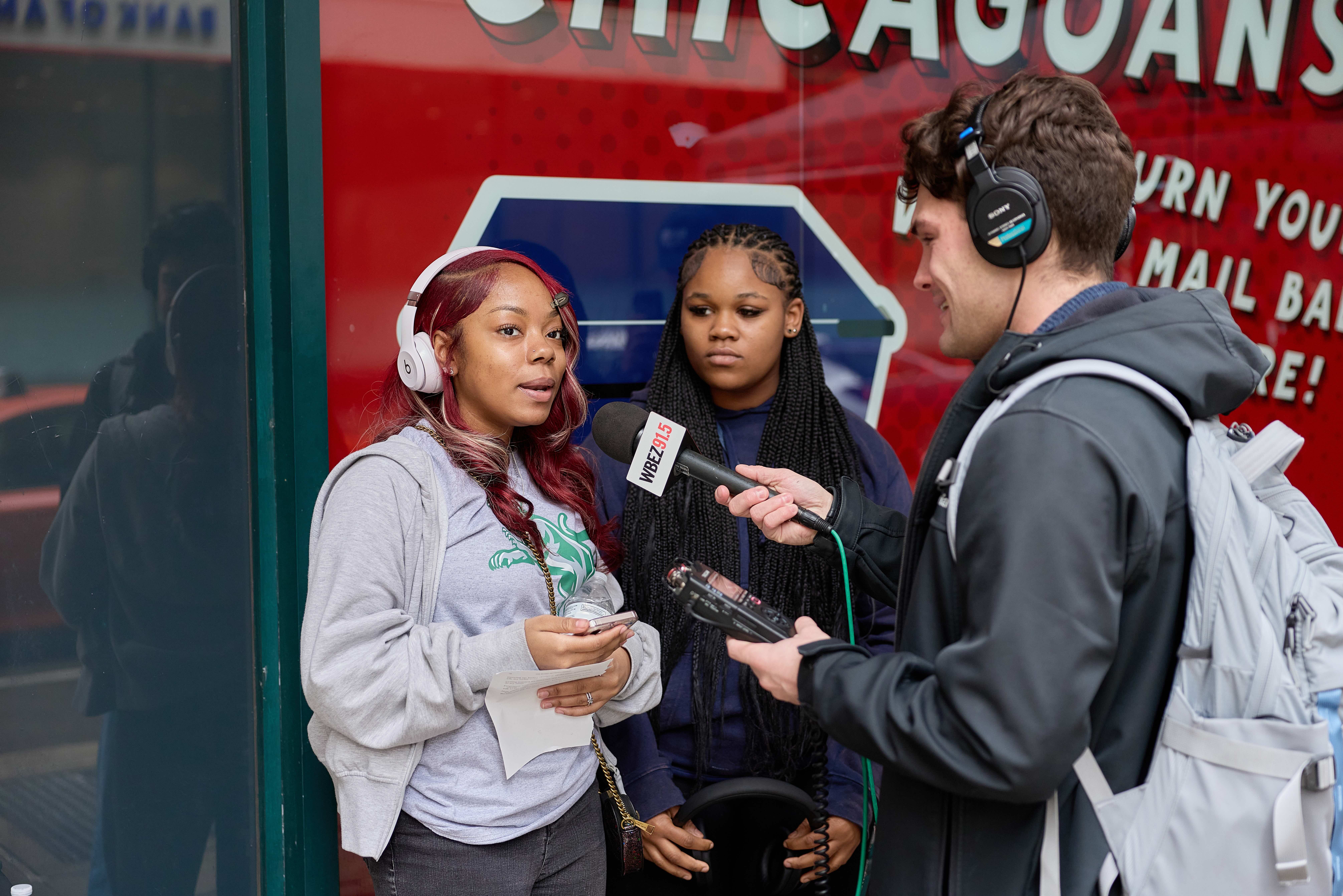 Two Gary Comer College Prep students are being interviewed by a WBEZ news reporter